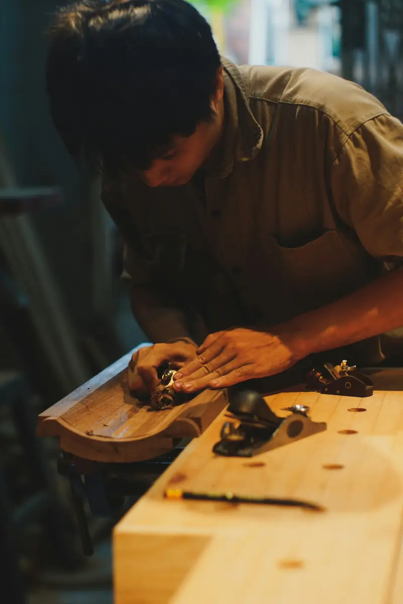 Ponçage manuel d’une pièce en bois, cale tenue à la main